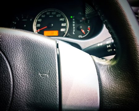 Car horn symbol at the steering wheel. Closeup photo.