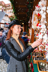 Girl examines soft toys bears at Christmas market