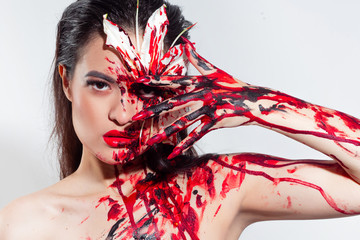 Blood Lily, scary and sexy Halloween look. Beautiful young brunette girl on white background