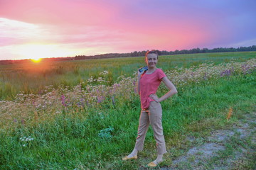 Summer girl in the field at sunset