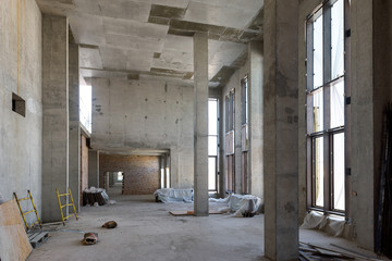 Construction of large building. Inside the modern construction site. Contemporary structure under construction with concrete walls, pillars, ceiling and floor. Concept of building business.