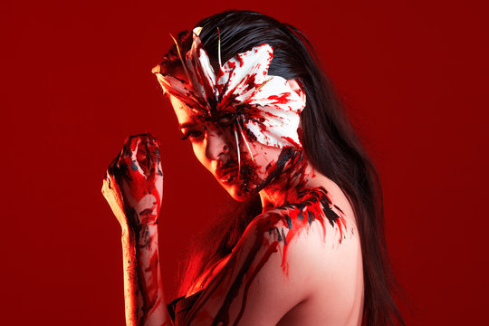 Blood Lily, scary and sexy Halloween image. Beautiful young woman