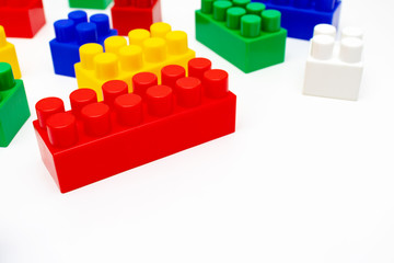 Many colorful toy plastic bricks, kit of blocks for building and constructing on white background with copy space