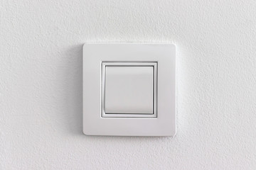 Single white light electric switch on a wall