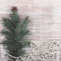 Christmas card. New Year accessories on white wooden background. Christmas celebration concept with pine tree and pearls. Place for text, Flat lay, top view, copy space