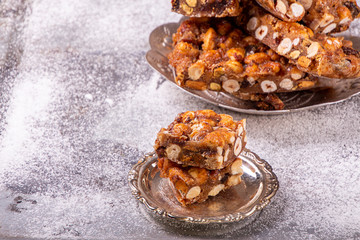 Italian sweet nuts, hazelnuts, almonds, figs, honey dessert over on sugar powder surfase