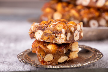 Italian sweet nuts, hazelnuts, almonds, figs, honey dessert over on sugar powder surfase