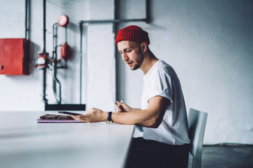 Millennial man with smartphone and stylus pen