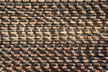 A fragment of the original brickwork of burnt bricks built by Ancient Rome. Background. Pattern. Ocher, brown.