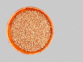 Buckwheat groats in a bamboo bowl on a gray background. Weight loss concept