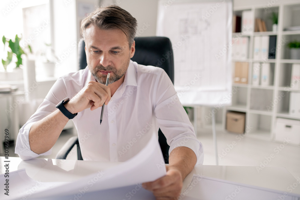 Aufkleber pensive engineer with pencil and paper looking at sketch while thinking of ideas