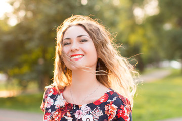 Happy woman laughing hotly on a city street. Close-up attractive caucasian woman with curly hair.