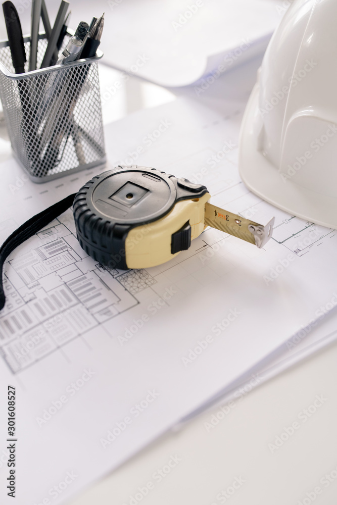 Poster Measuring tape, bunch of pencils and sketches on workplace of modern architect