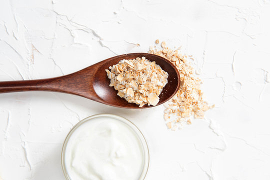 Homemade cosmetics with yogurt and oatmeal on a white background. Ingredients for the mask