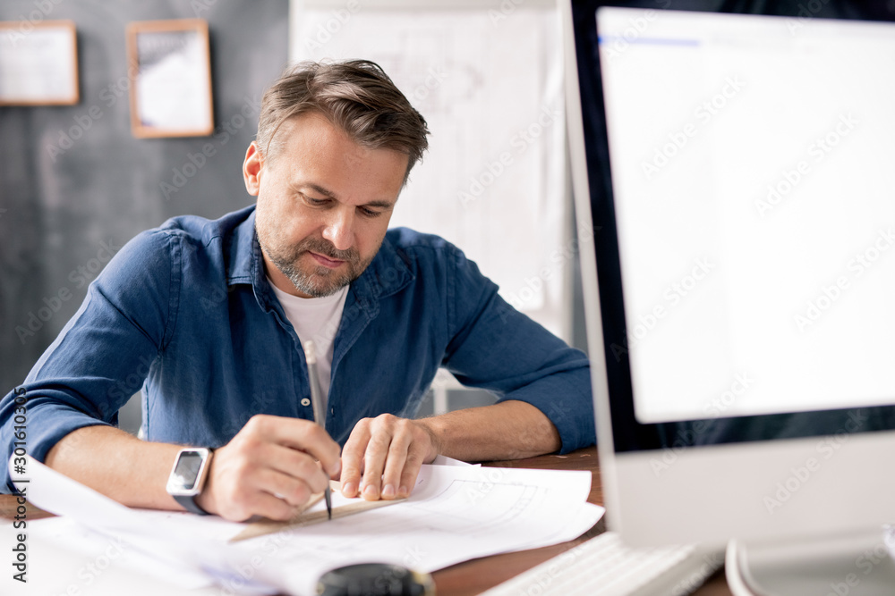 Aufkleber Professional engineer with pencil pointing at blueprint while drawing sketch