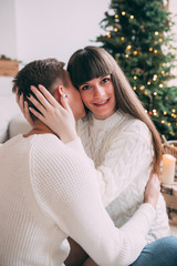 Photo shoot in the studio of a young married couple. Photographing of pregnancy. A guy with a girl is celebrating Christmas. New Year's love story.