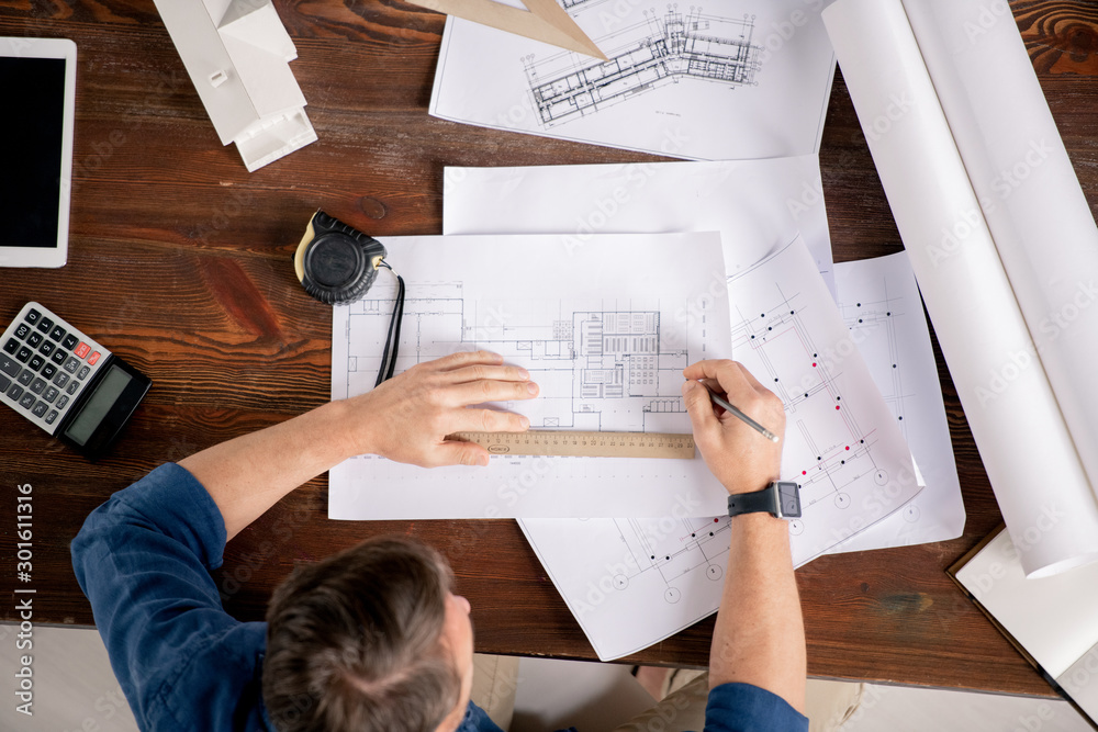 Poster Overview of contemporary engineer sitting by table and correcting sketches