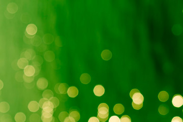 abstract spots of glowing gloden yellow light on a blurred green background - Powered by Adobe