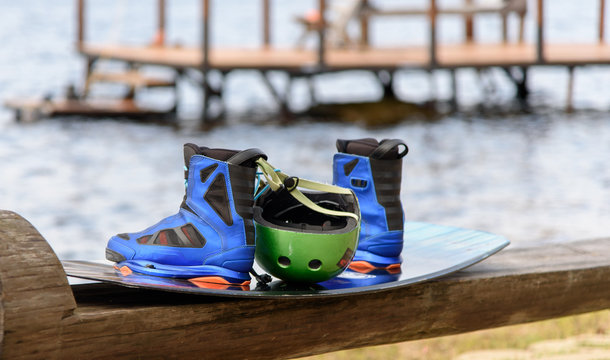 Wakeboarding boots, helmet and board on a wooden bench. Lifestyle concept