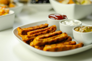 Roast chicken formed in straws, bites of succulent chicken breast with different sauces