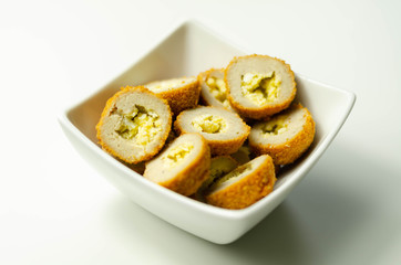 Savory mini scotch eggs in white ceramic bowl, traditional English snack