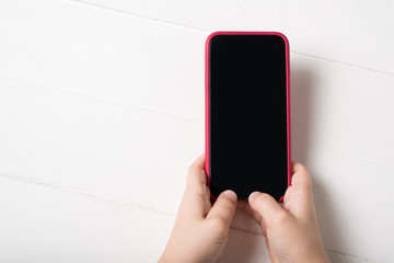 Smartphone in children's hands on a light background
