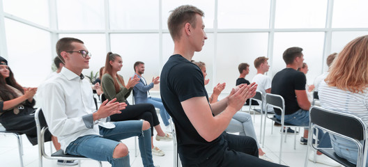 rear view. young people applaud during the youth seminar.