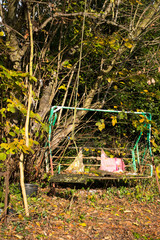 Old shabby neglected garden swing seat