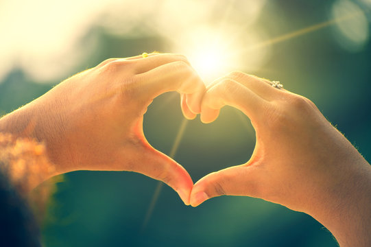 The Hands Of Women And Men Are The Heart Shape With The Sun Light Passing Through The Hands