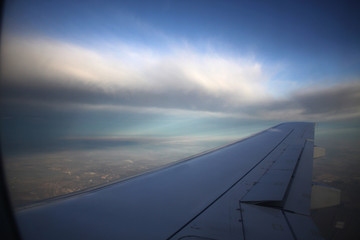 Fototapeta na wymiar Wing of an airplane flying above the clouds. Travelling concept