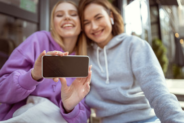 Joyful blonde leaning on her best friend