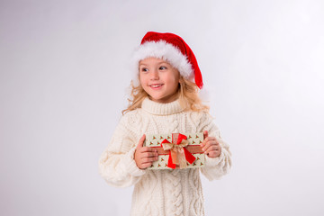 little blonde girl in Santa hat holding gift box, isolate on white background, space for text
