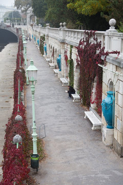 Jugendstil in Wien: Mit blauen Vasen und gr&uuml;nen Laternen geschm&uuml;ckte Promenade entlang des Flusses Wien am Stadtpark im Herbst bei Nebel