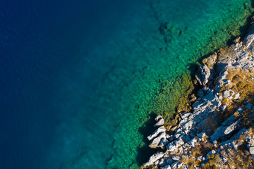 Fototapeta na wymiar Aerial shot of beach with incredible turquoise colors and rocky cliffs greek island