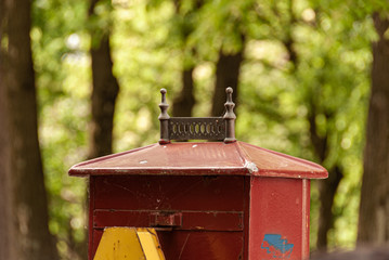 Vintage red mailbox with blurry forest background