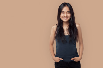 Obraz premium Young adult asian girl looking at camera, holding hand in pockets