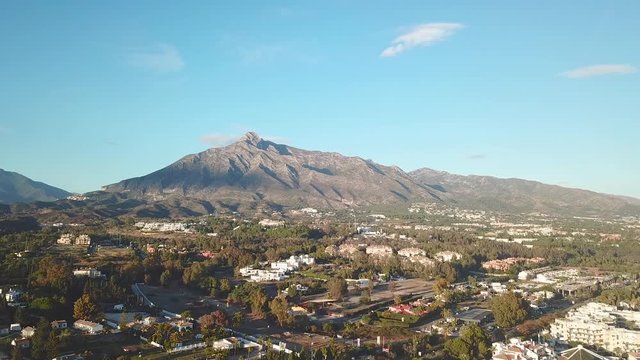 Panoramic aerial view of Marbella. View of La Concha Mountain . Beautiful Andalusian House Urbanisation Architecture and highway A7. Golden Hour, warm light, beautiful colours at sunset. Left Rotation