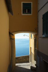 The ocean seen from an arch of a building in the Cinque Terre park