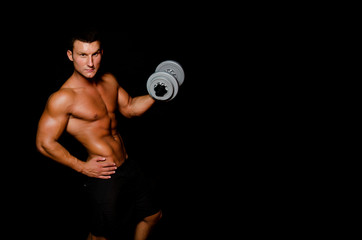 Fototapeta na wymiar Fitness and healthy lifestyle. Young attractive guy at the gym.