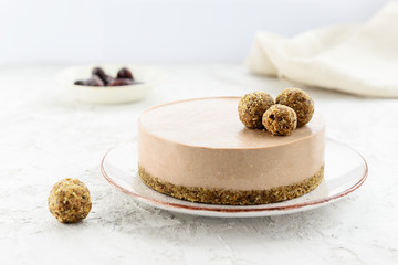 Chocolate raw cheesecake garnished with energy balls. Gluten free.