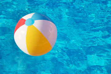 Colorful inflatable ball floating in swimming pool