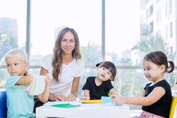 Nursery teacher and her students make paper crafts