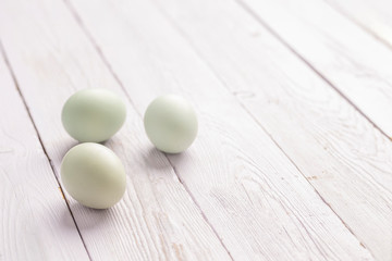 Three Blue Green Eggs on Wood background