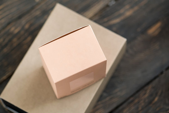 Two gift boxes, blush coral color and craft paper. Stylish minimalist brand packaging concept.