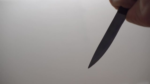 Hand stabbing someone with a butcher knife, ritual killing, horror scene. Blood-chilling horror thriller shot