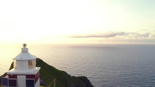 Aerial drone video flying over Kallur lighthouse on green hills of Kalsoy island, Faroe islands, Denmark. UHD 4k video