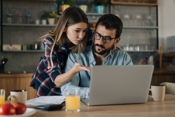 Young couple having problems with paying their bills over Internet