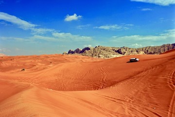 Fototapeta na wymiar Jeep crossing the sand dunes in the Dubai desert