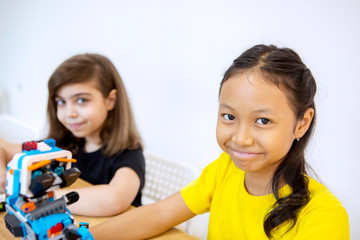 Two schoolgirls constructing a blocks robot