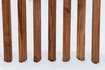 A picket fence covered with snow and the snow is still coming down.Winter wooden fence with snow. New Year's collection. Great for background for New Year and Christmas design.Wooden fence covered